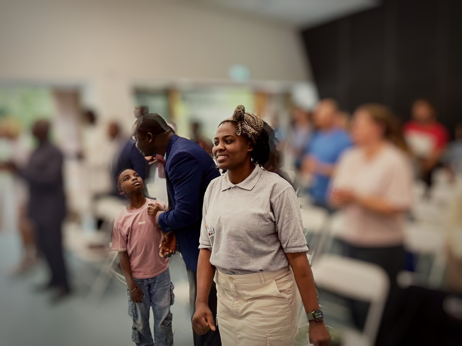 Members of Glory Community Church standing and smiling during a Sunday service at Firstsite