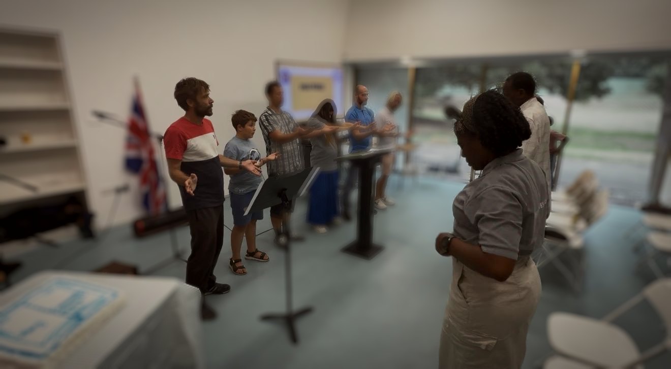 Church members praying together at Firstsite, hands outstretched